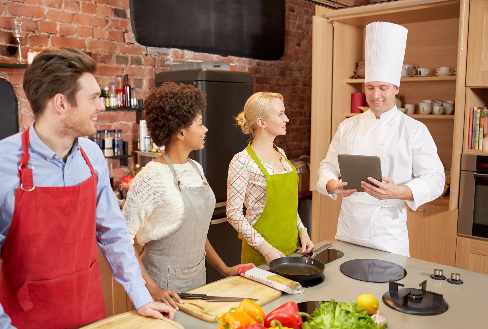 Wide shot of an online class with multiple participants cooking at home
